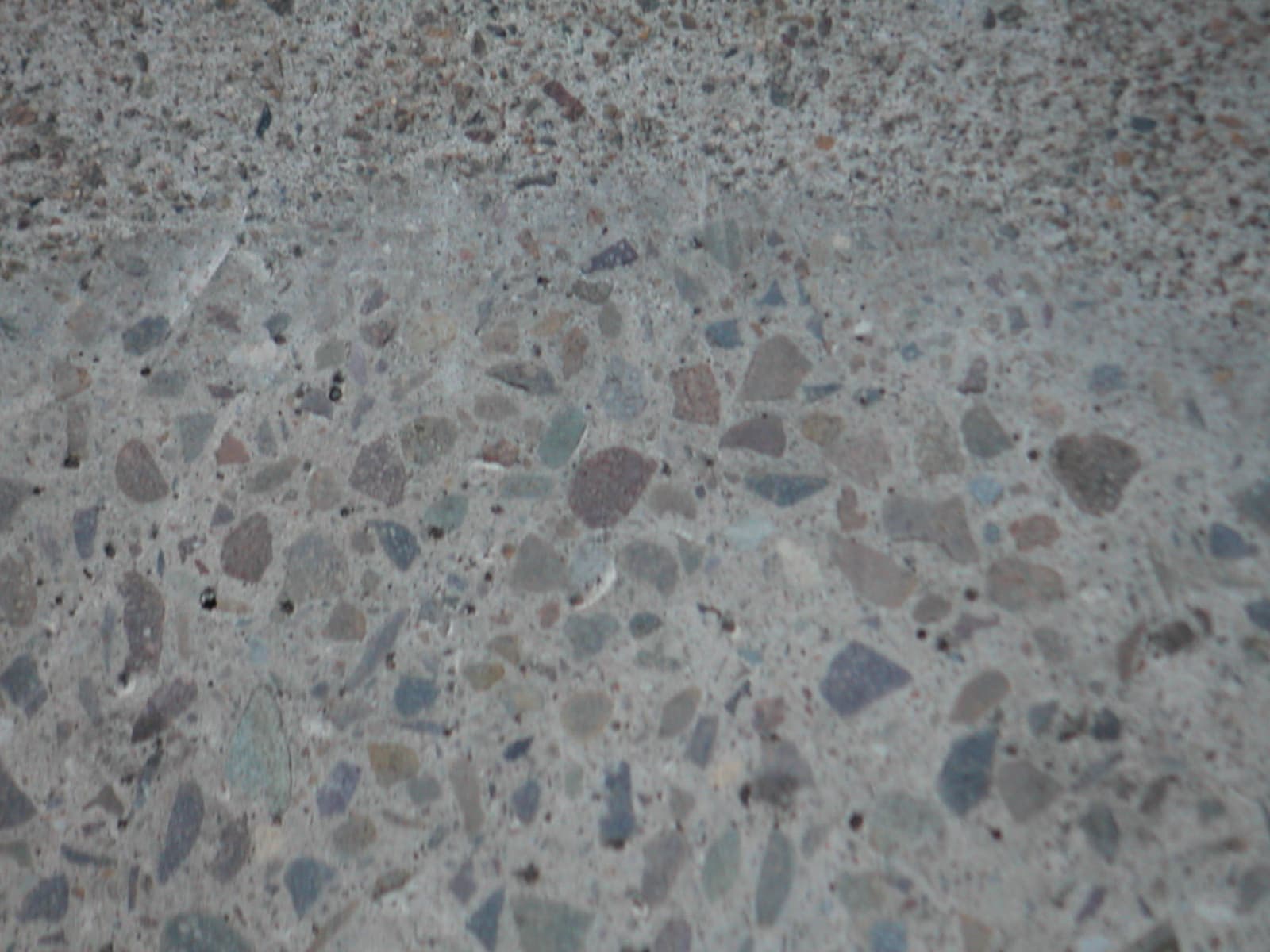 Concrete surface with exposed aggregate being ground